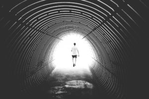 grayscale photo of man walking in hole