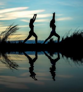 silhouette of women on lake against sky