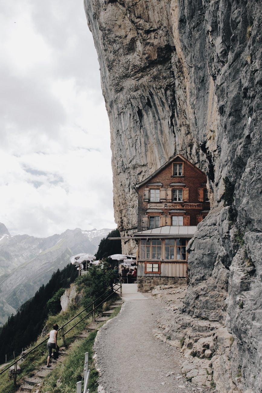 brown wooden house on edge of cliff
